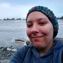 Photo of Seirra Wolfe in front of a rocky coast.